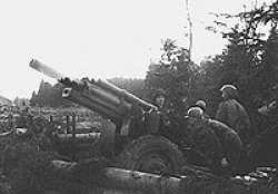 This picture of a crew firing its 105mm Howitzer was taken in the Schnee Eifel region of Germany, east of Prum. The gun crew member facing the camera is Irving. Having just fired a round toward Prum in support of our attacking infantry. The tube of the gun looks to be transparent because it is still in recoil.
