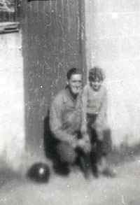 A picture from Felix's private collection, with an unknown GI and, as we believe, a local French boy on his knee in Cherbourg, France.