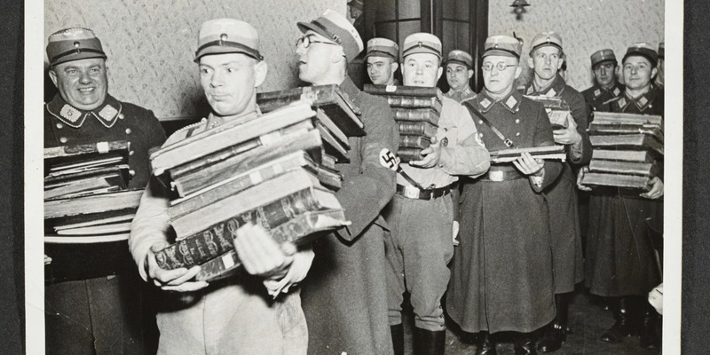 Religious books and Torah scrolls are removed from a synagogue during the pogrom.