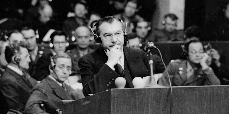Chief U.S. Prosecutor Justice Robert H. Jackson wearing headphones at the podium during the International Military Tribunal in Nuremberg, circa 1945–1946.