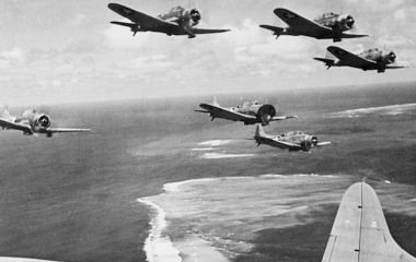 Imperial Japanese Navy aircraft fly over Midway Atoll during the opening attacks on 4 June 1942, beginning one of the most decisive naval battles of the Second World War.