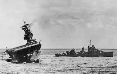 The abandoned USS Yorktown lists heavily after suffering bomb and torpedo damage during the Battle of Midway. She eventually sank on 7 June 1942.