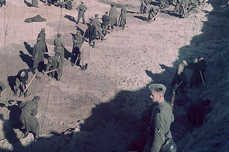 SS guarding prisoners who had to dig the pit