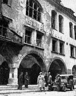 THE HOFBRAUHAUS MUNICH, CP 157TH INF, 45TH DIVISION 1945  This is a picture of the Hofbrauhaus in Munich, Germany where one Adolph Hitler led his first abortive attempt to unseat organized government by violence. His Putsch from this beer hall was a dismal failure and ended with Der Fuerher flat on his face dodging bullets a few blocks from the spot where he declared to his followers that he would win or die. On April 30, 1945, Munich fell before elements of the 45th and 42nd divisions. The 157th Infantry won the race for the Hofbrauhaus and their CP sign was the first to be placed on it. This caption was taken from the 157th Book, Eager for Duty. Picture was taken from the Forty Fifth Division Book.