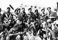 Colin Reynolds (Standing, far right and holding the Sten gun) before boarding the Dakota to jump into Palestine.