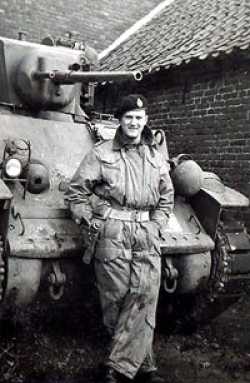 Ian standing in front of a Stuart reconnaisance tank somewhere in Belgium