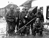 William Bramswig is the one holding the bottle the picture was taken in a deserted town in Germany 1945.
