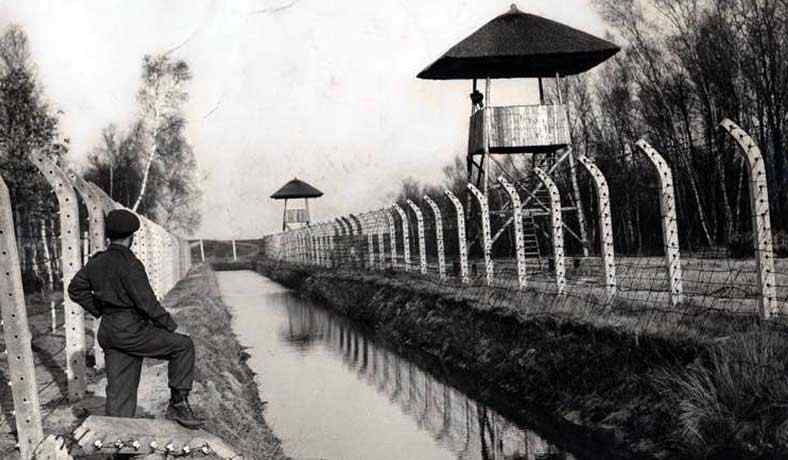 Barbed wire fences with a water trench surrounding the camp area