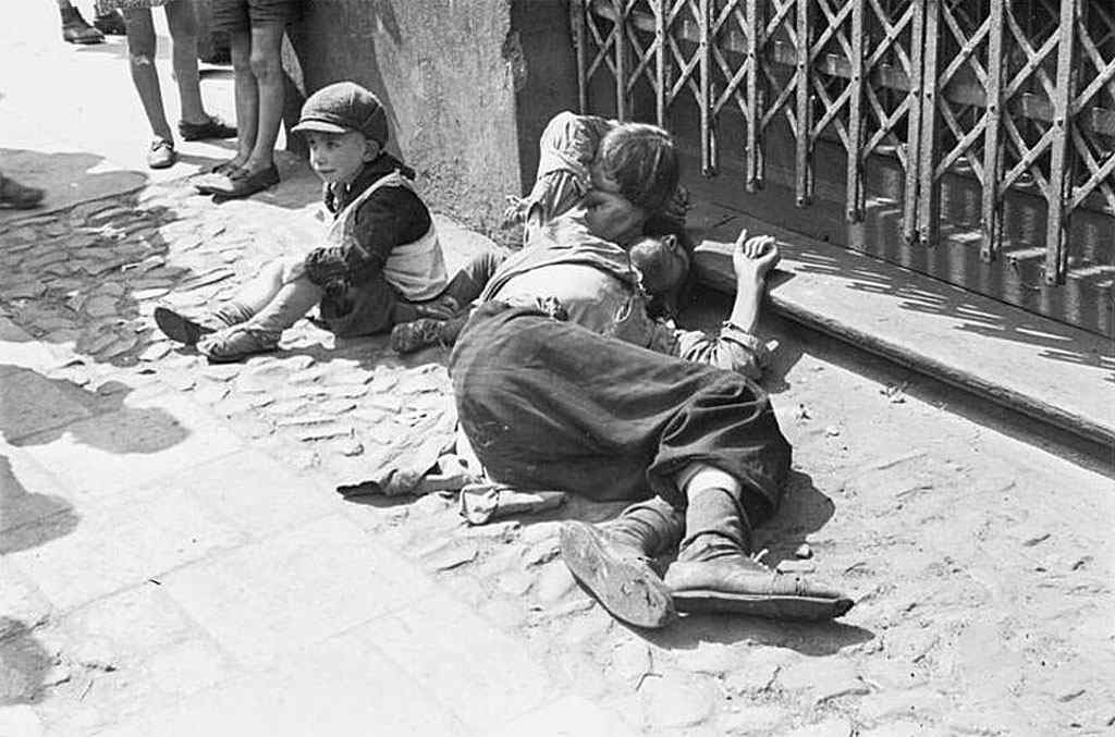 A starving man and his two emaciated children begging for food.