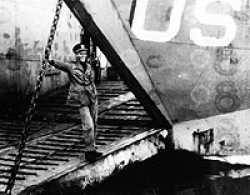 Don Irwin standing on the ramp of the LCT 614. Ship was on the beach to have a screw repaired that was damaged in the Omaha Beach landing.