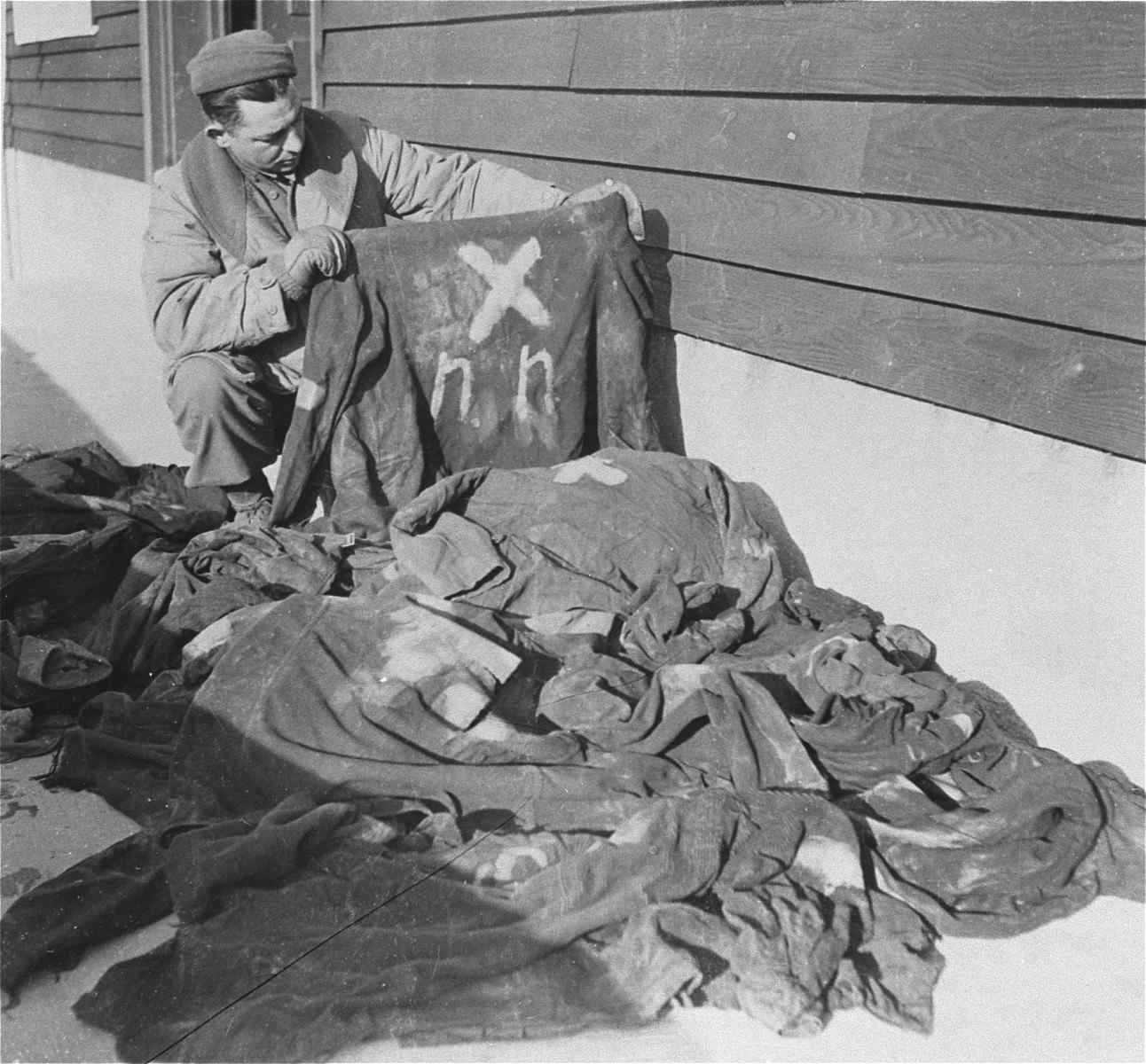 An American soldier examines markings on prisoners clothing in Natzweiler-Struthof