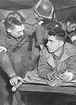 John, here on the left, in an aid station, giving comfort to the wounded and sick.