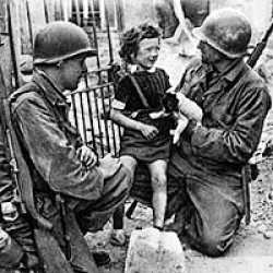 Soldiers of the 29th Infantry Division helping the local population in Normandy.