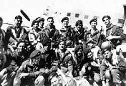 Colin Reynolds (Standing, far right and holding the Sten gun) before boarding the Dakota to jump into Palestine.