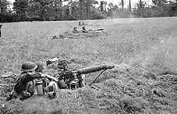 June 1944, near Tilly Sur Seulle, Normandy, France. George is in the center firing the Vickers.