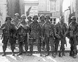 From left to right: Pfc, Forrest L. Guth, Pvt. Francis J. Mellet, Pvt. David E. Morris, Pfc. Daniel B. West, Sgt. Floyd M. Talbert and Pfc. Campbell T. Smith in this famous picture in the local square at Ste Marie du Mont, Normandy, France