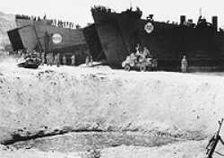 HM LST-62 (on the right) and HM LST-405 beached, 3 September 1943 (Invasion Day) at Reggio Italy, while unloading vehicles.Notice the bomb crater in the front of the picture.