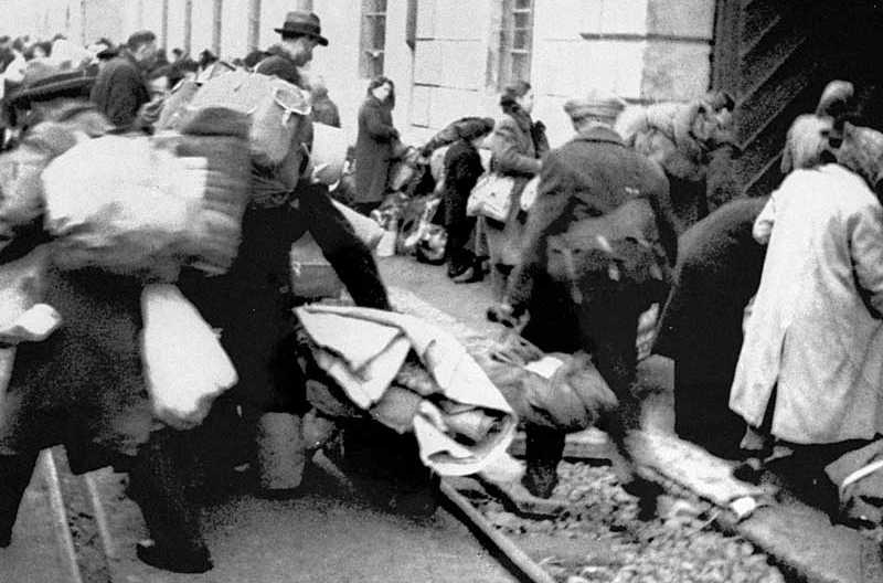 Dutch Jews who have just arrived in Theresienstadt are herded to one of the entrances to the camp.