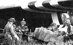 British Paratroopers standing in front of their glider, notice the white invasion stripes on the wings.
