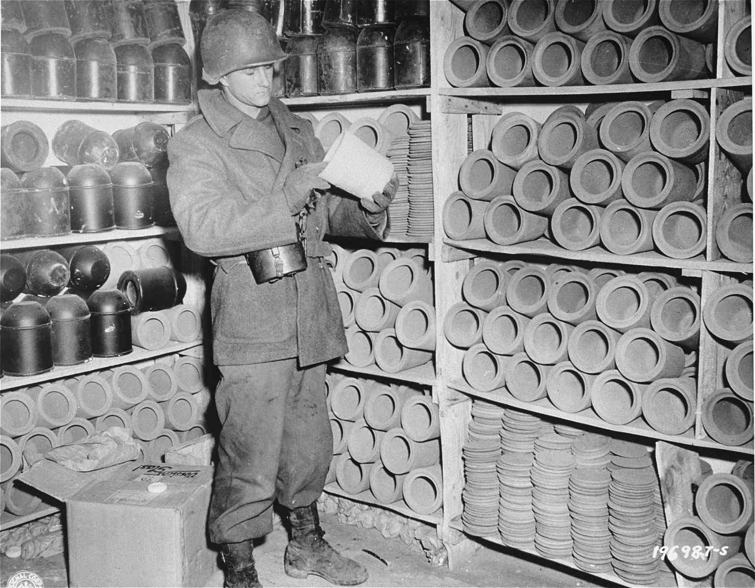 American soldier examines an urn used to bury the ashes of cremated prisoners